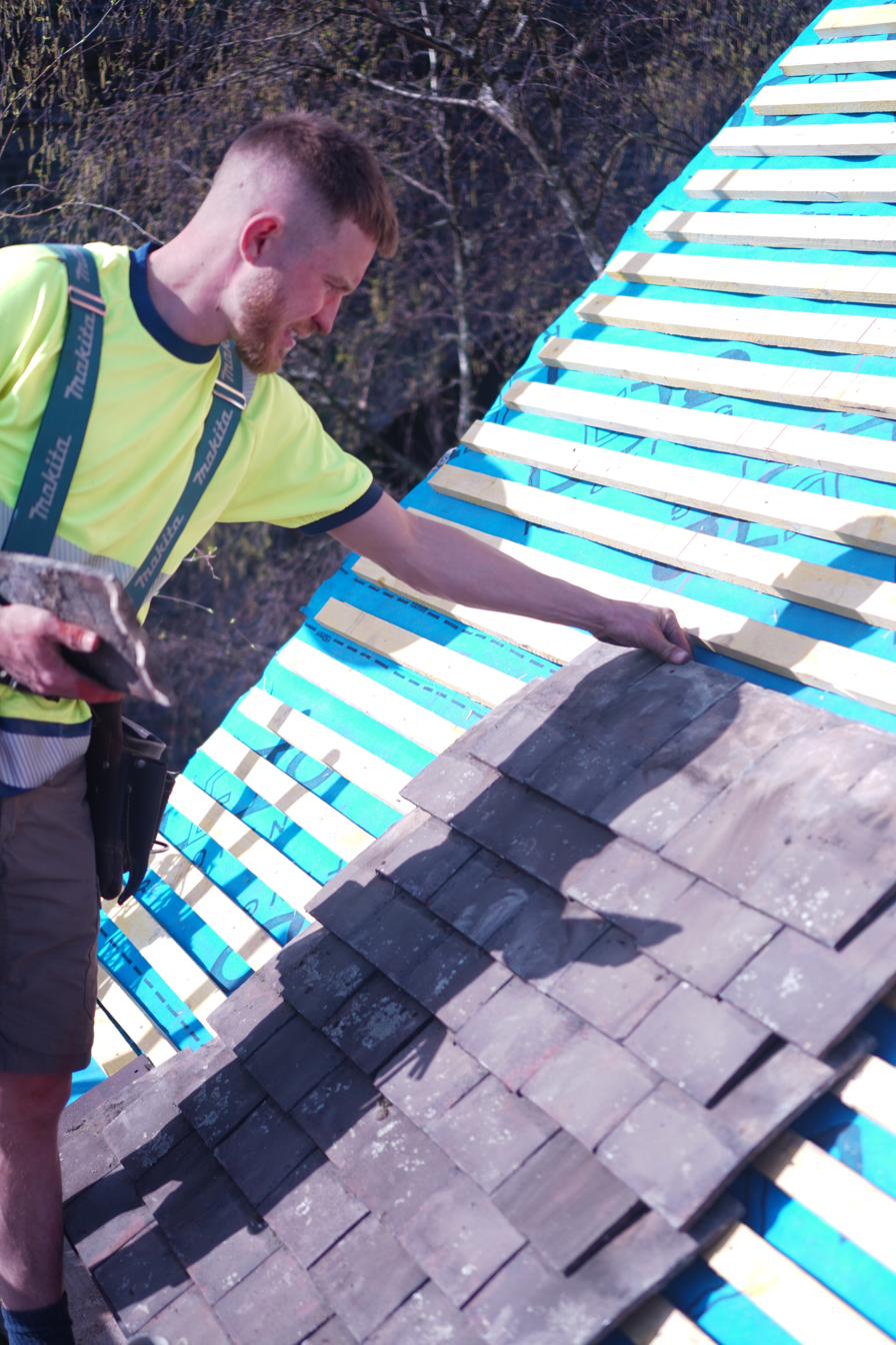 Swifts Roofing & Construction — skilled roofer at work laying slate tiles