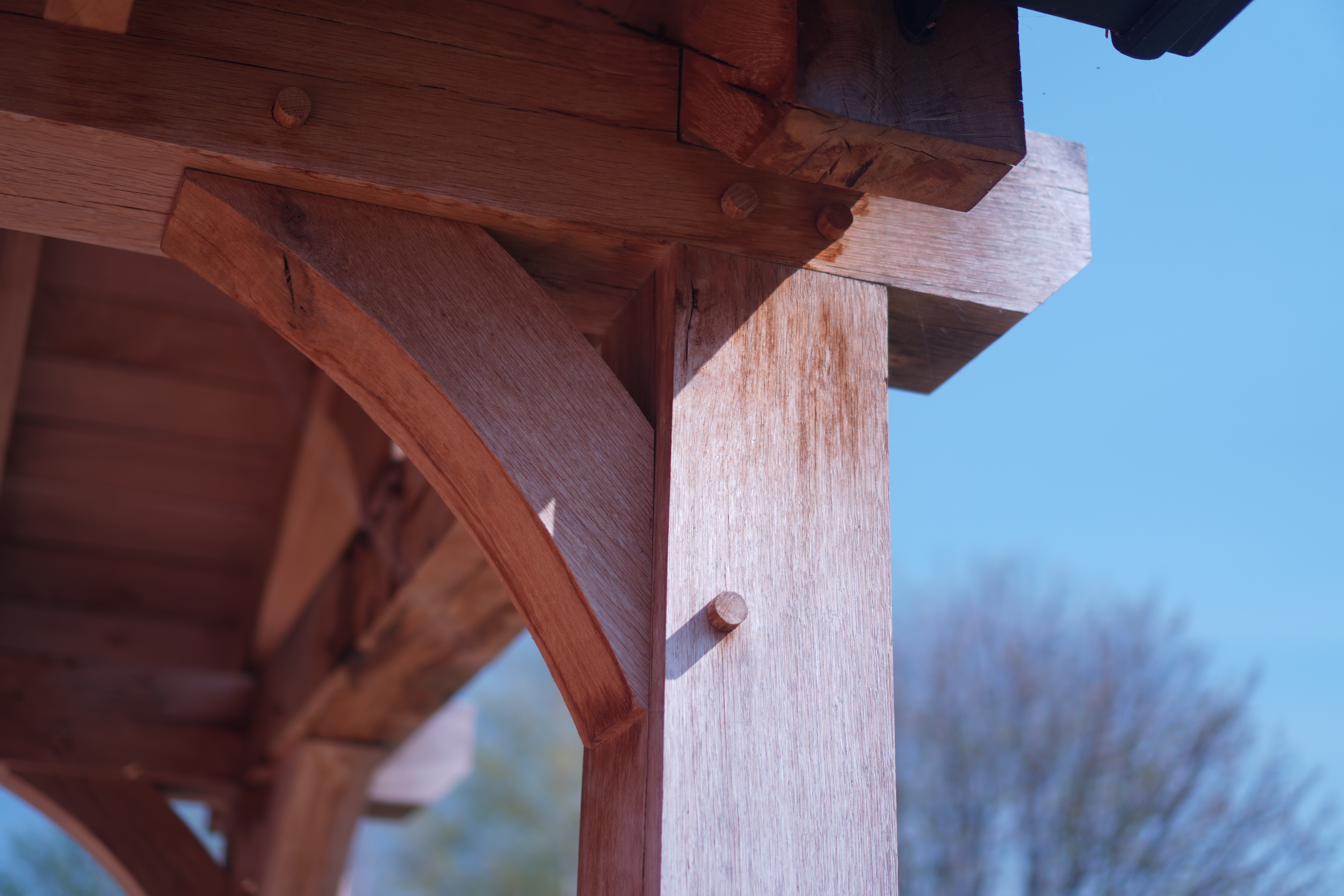 Precision oak timber frame porch construction — part of a full roofing and construction project