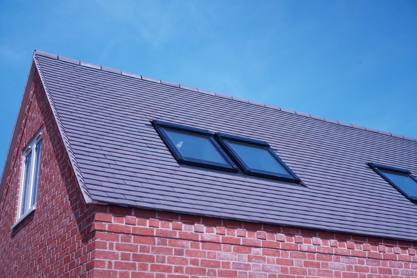 Natural slate roof with Velux skylights on red brick property